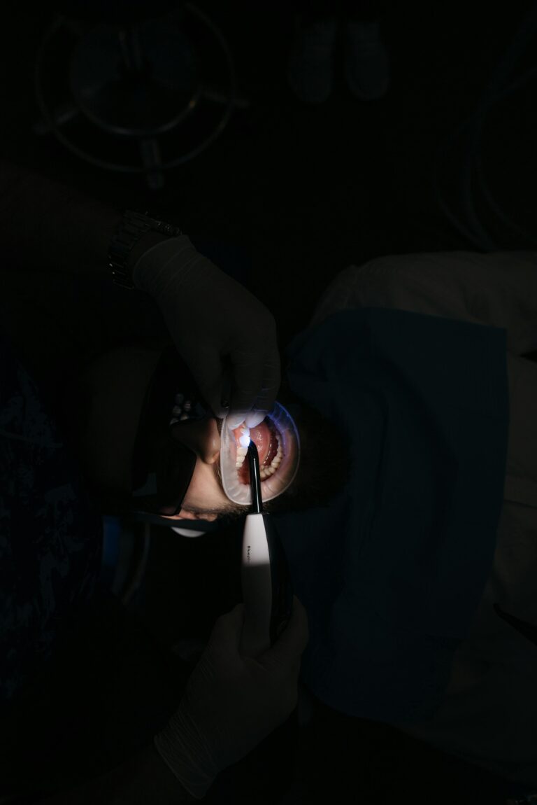 A dentist performing a dental procedure using a curing light on a patient wearing protective glasses in a Turkish dental clinic.